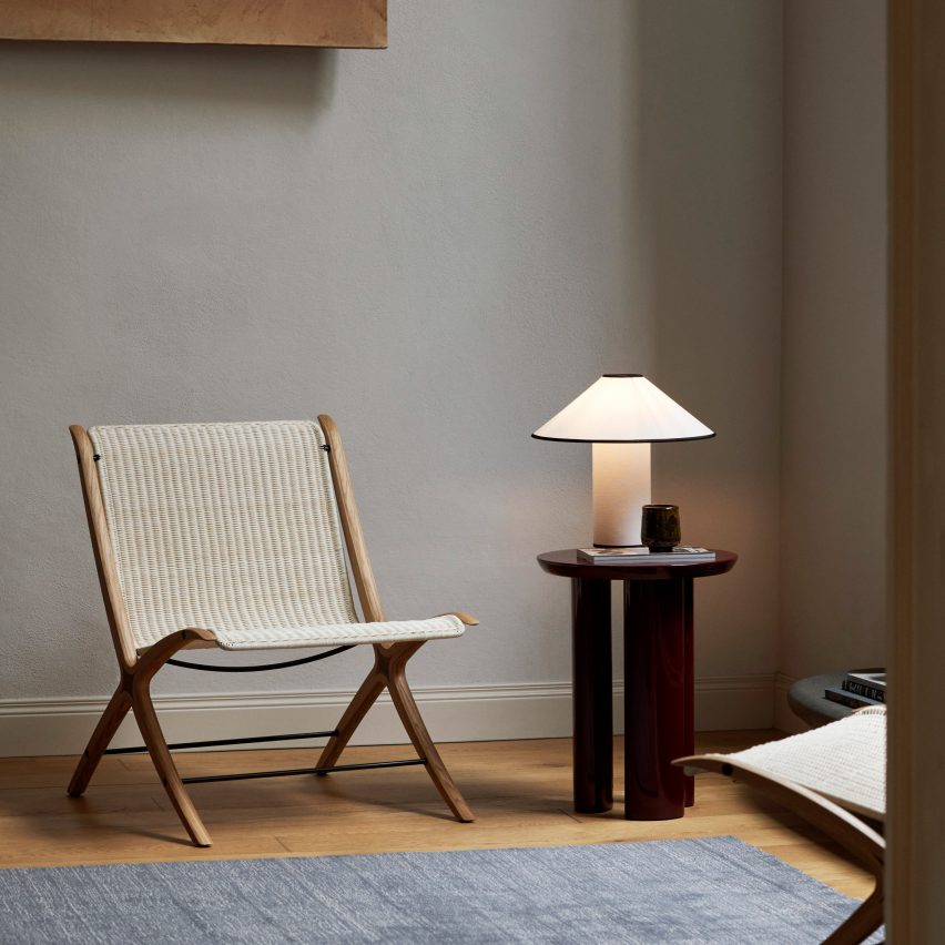 Photograph showing rattan and wooden chair by side table with lamp