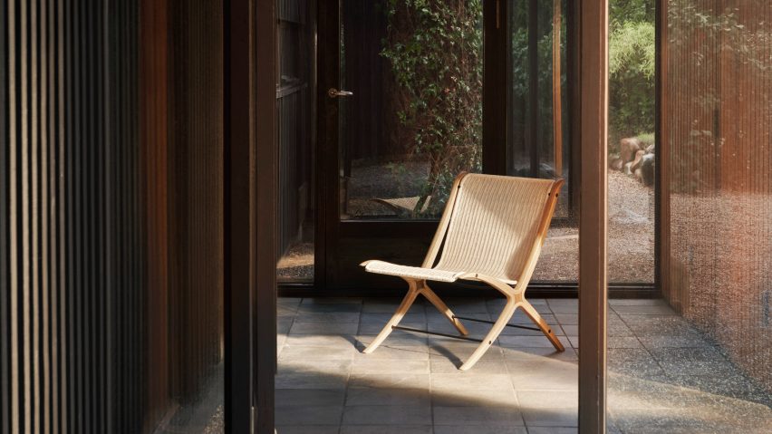 Photograph showing rattan and wooden chair in glazed garden room
