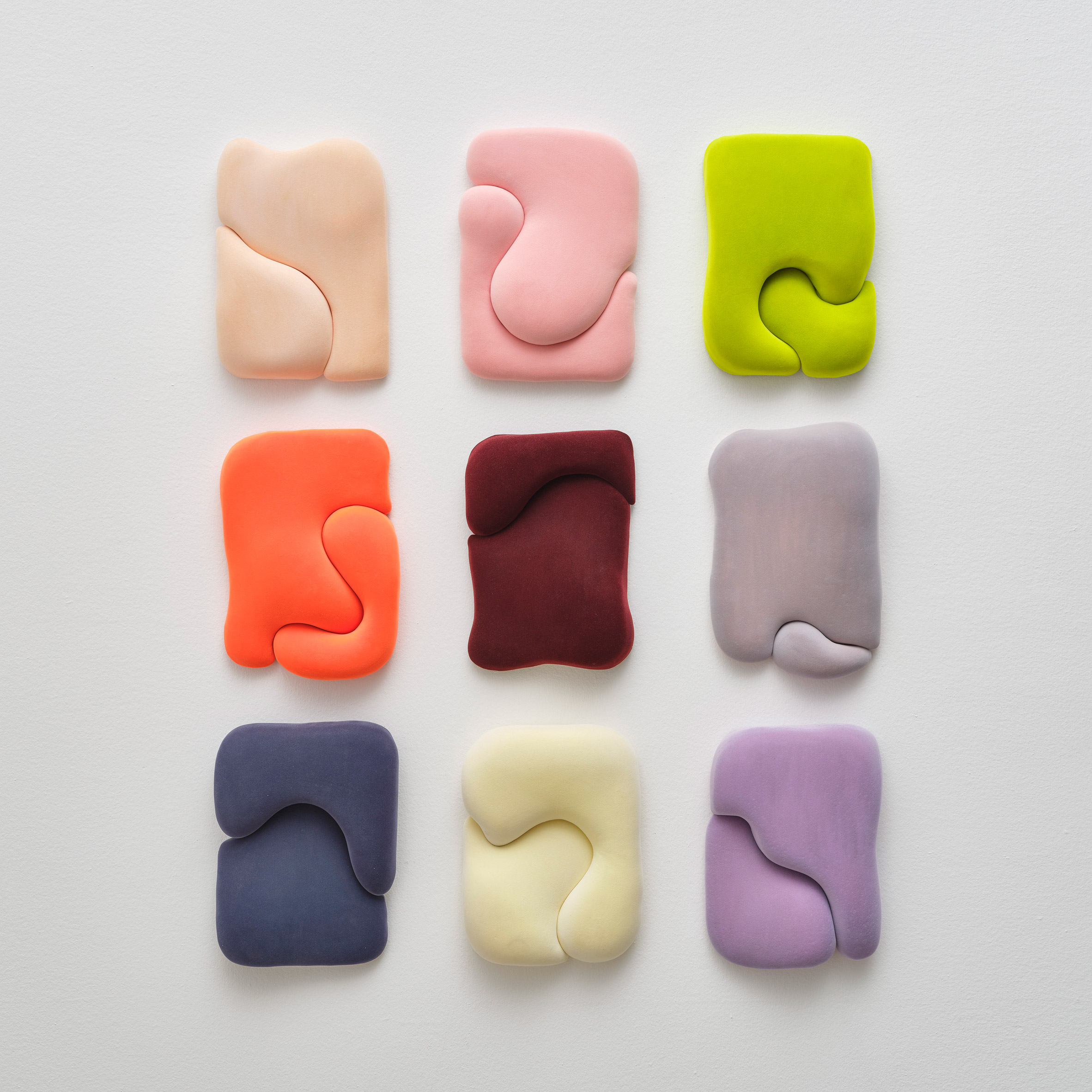 Photograph of the nine Blob series of sculptures mounted on a wall