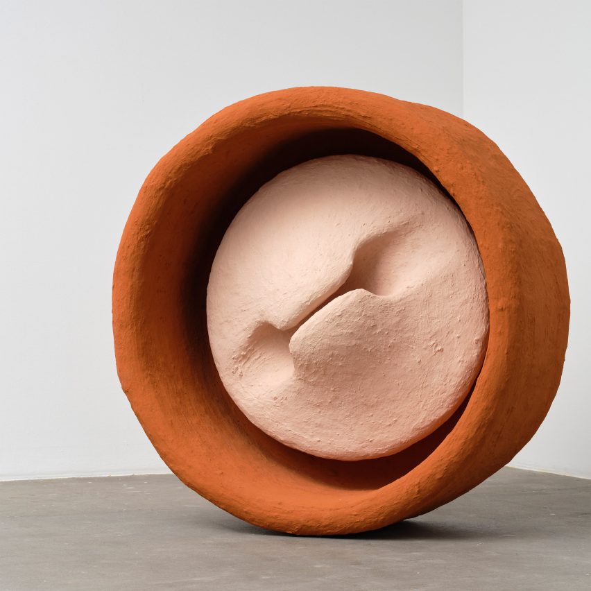 Photograph of a large-scale circular sculpture in pink and orange