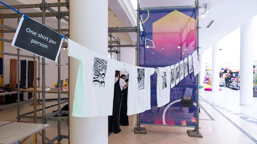 Photograph showing t-shirts hung up on a line in a studio