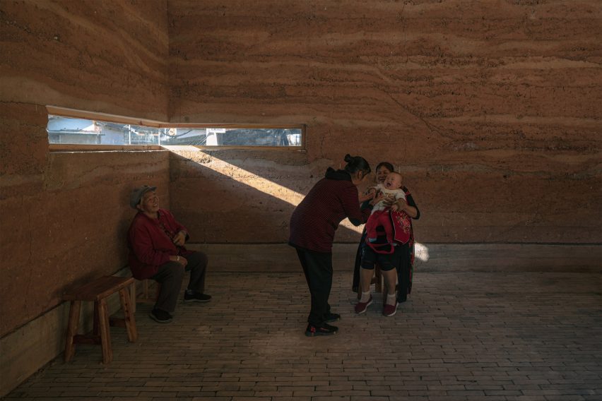 Interior image of a space that is zoned by rammed-earth walls