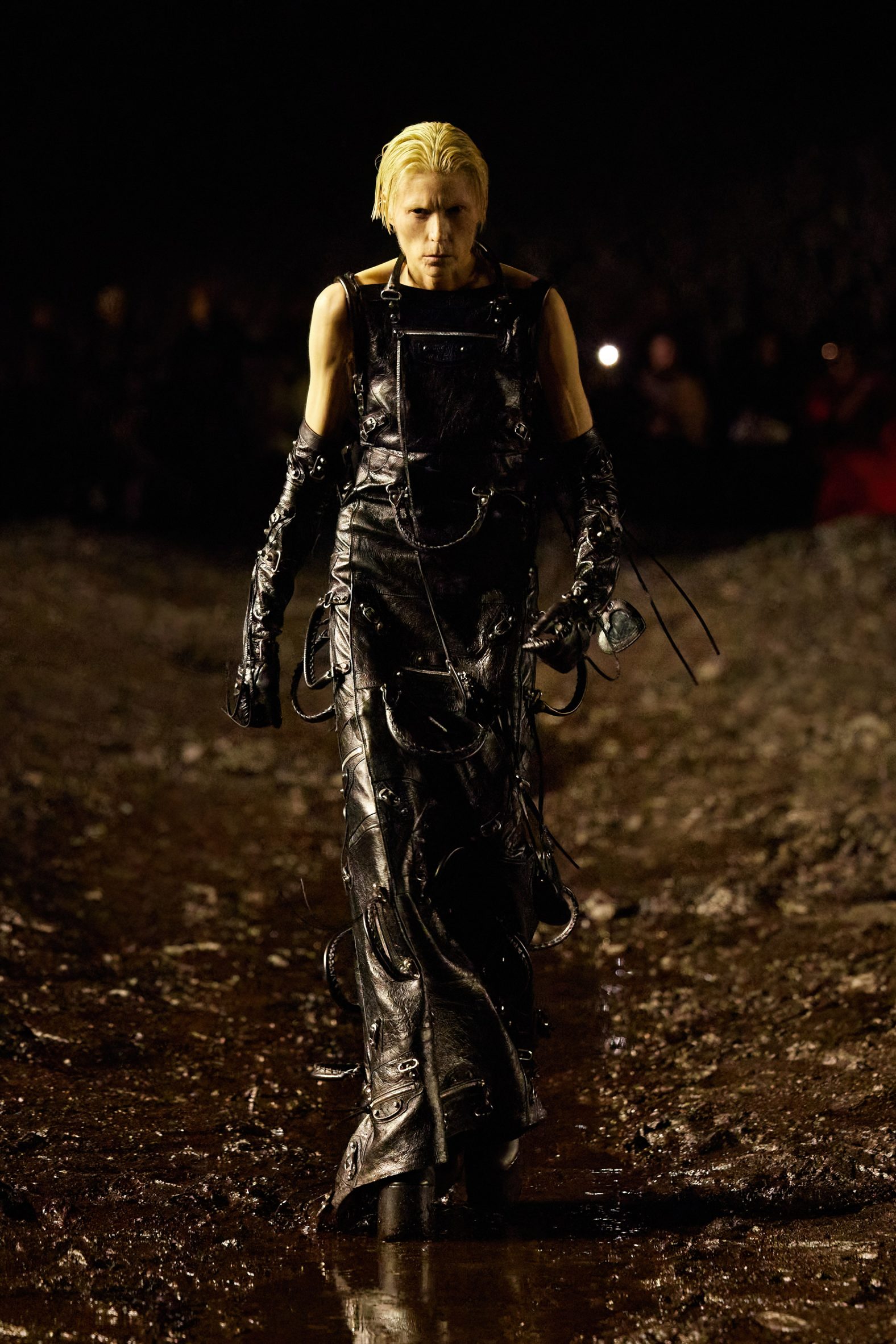 A model is pictured walking the mud runway in clothes made from leather bags