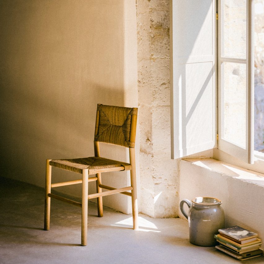 Photograph showing chair by window in rustic interior