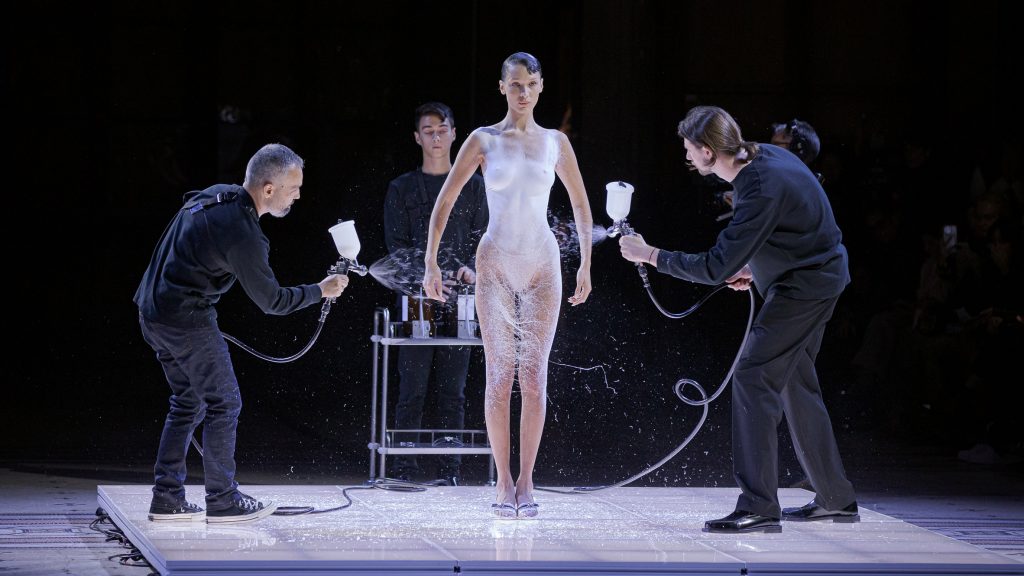 Non-woven dress sprayed onto models body on Coperni runway at Paris Fashion Week