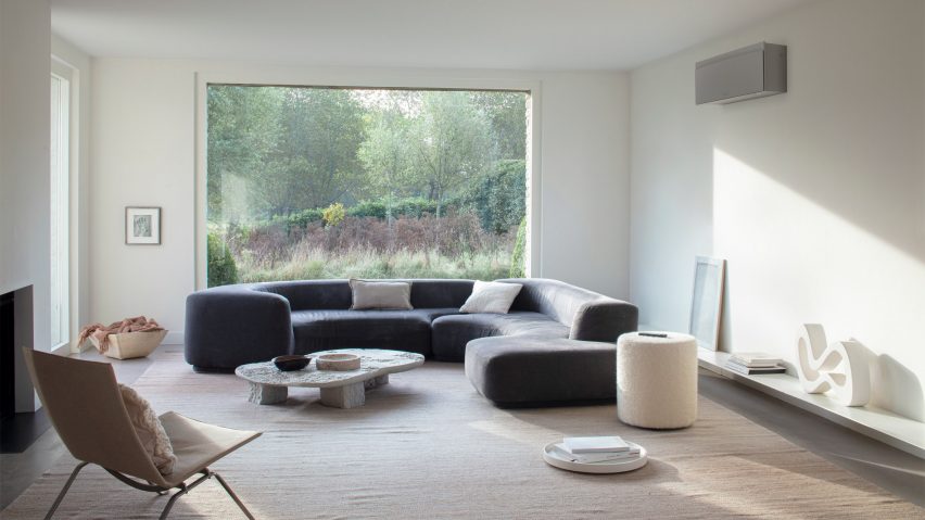 Emura unit by Daikin in a living room with a large curved sofa