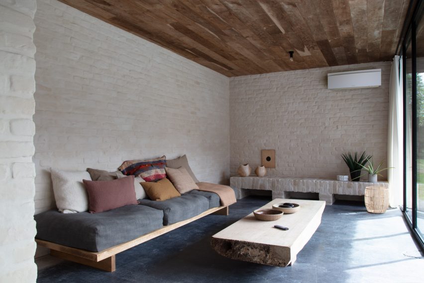 Unité de climatisation intérieure Daikin White Emura dans le salon avec murs blancs et moquette foncée