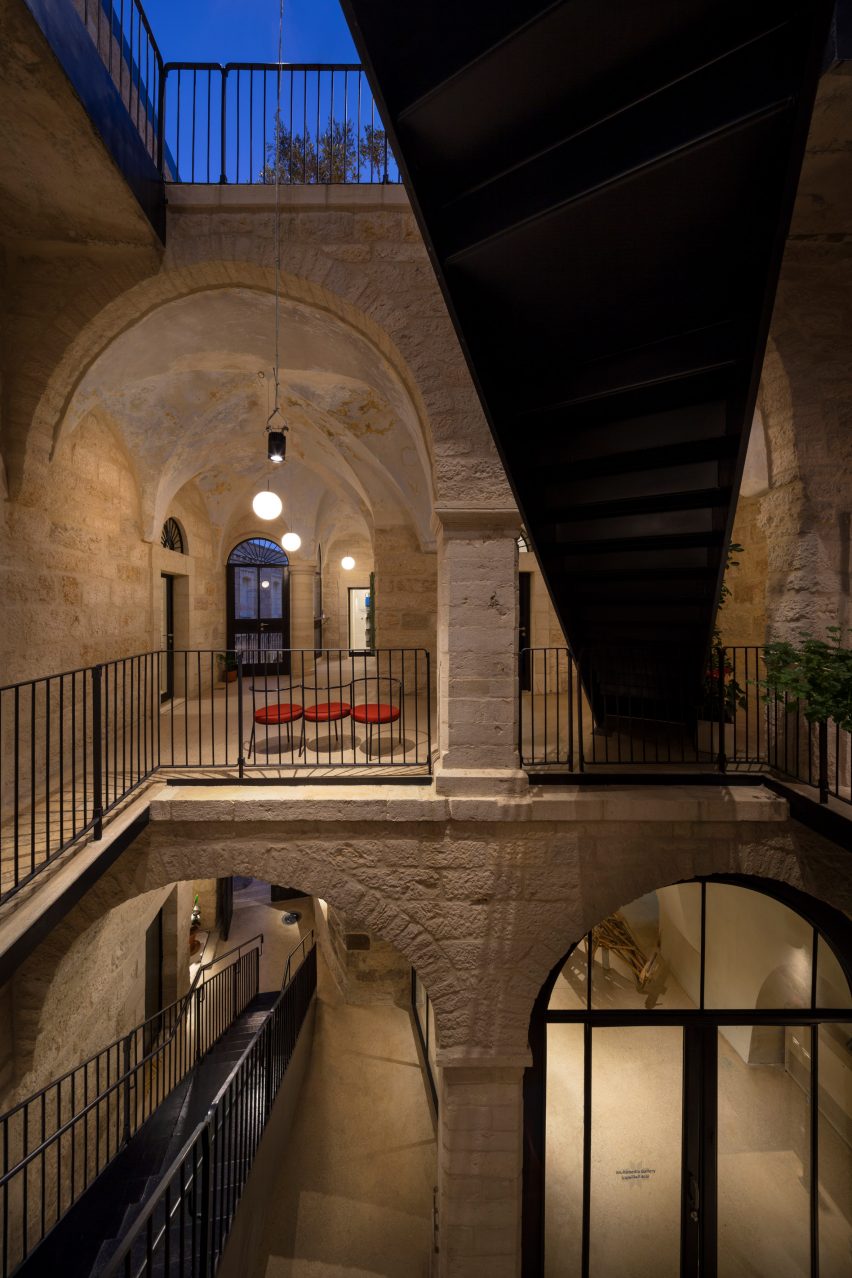 Interior hosh of the Dar al Majour complex with historic stone vaults and arches and new black steel staircase and balustrades