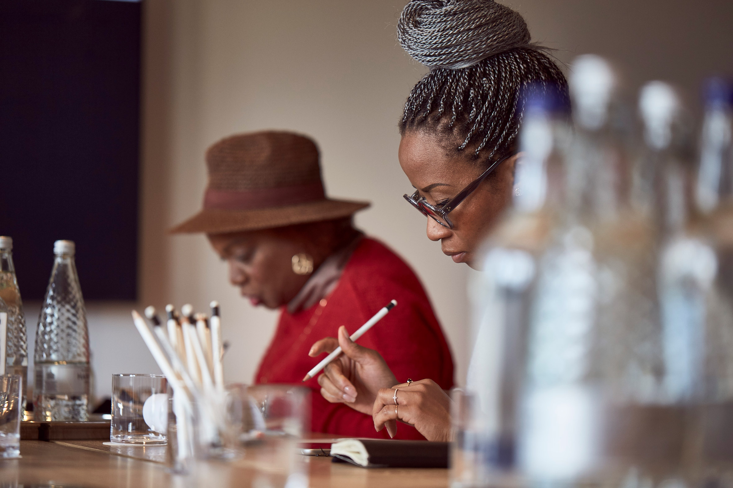 Anette Fisher and Tosin Oshinowo sat by table with pencils