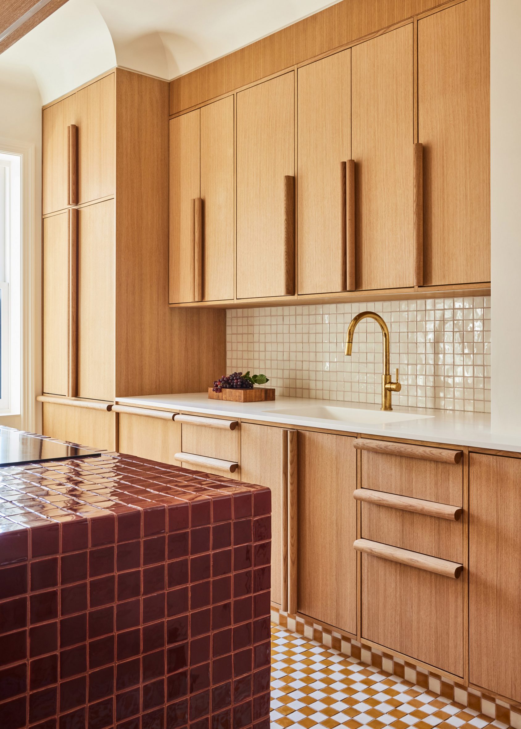 Kitchen with oxblood tiled island and white oak cabinets