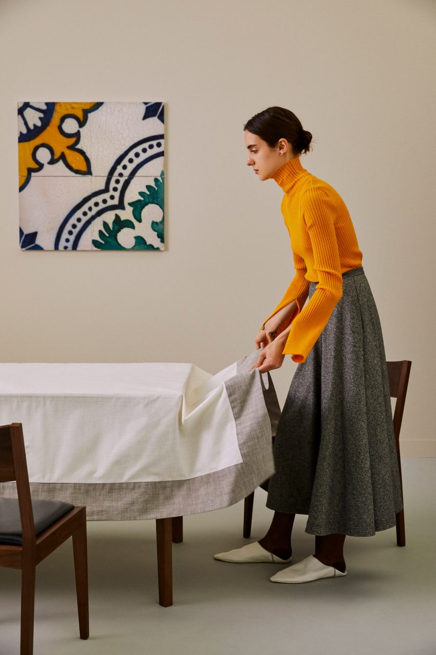 Person laying tablecloth on table