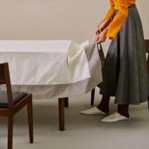 Person laying tablecloth on table