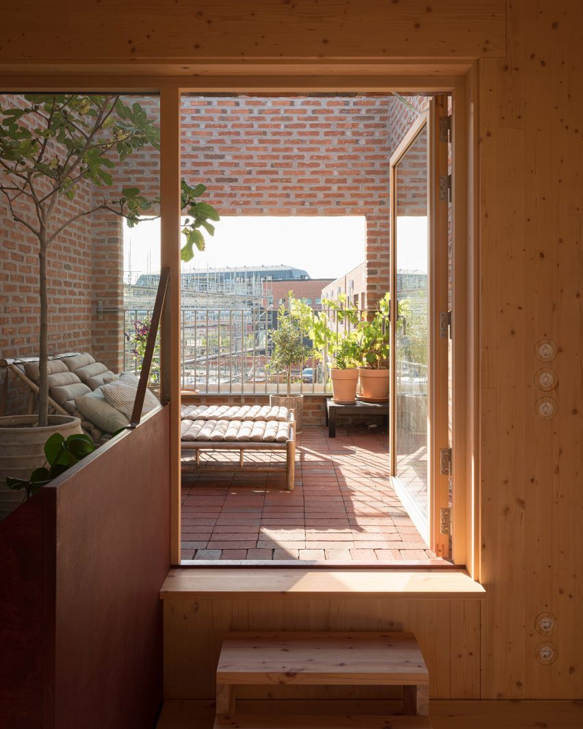 Image of a brick enclosed terrace with sun loungers pictured from the interior