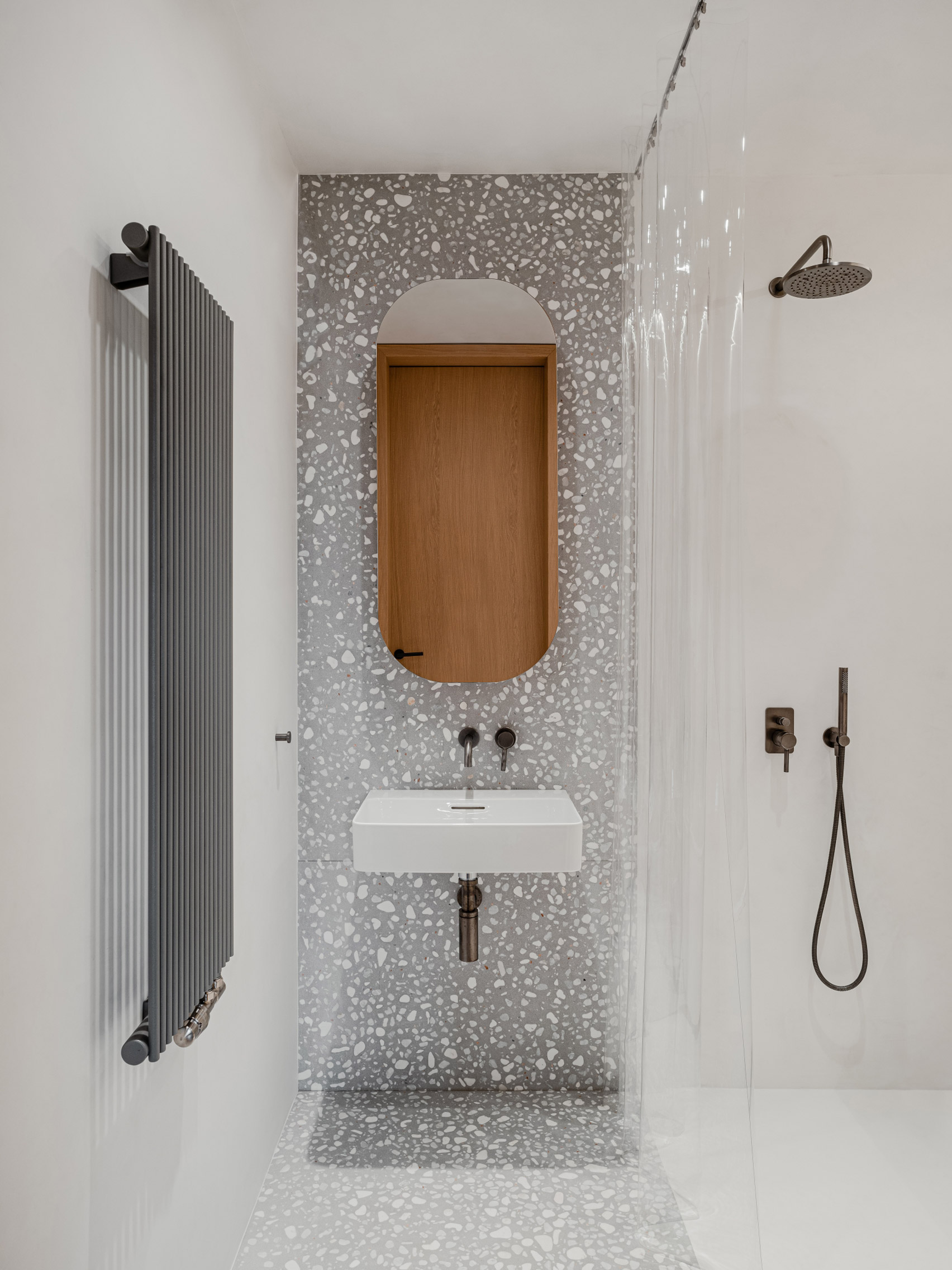 Bathroom with grey terrazzo panelling in Gdańsk apartment interior by ACOS