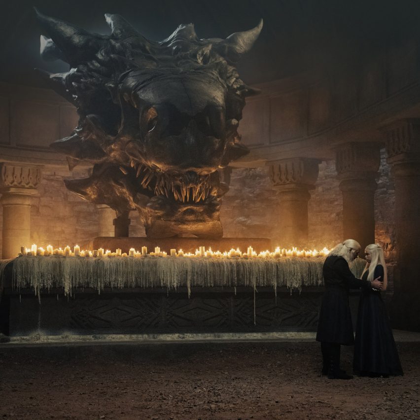 A large dragon head above an altar with candles