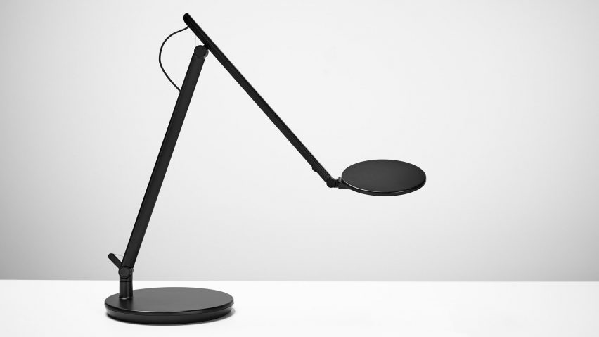 A black desk lamp on a white surface
