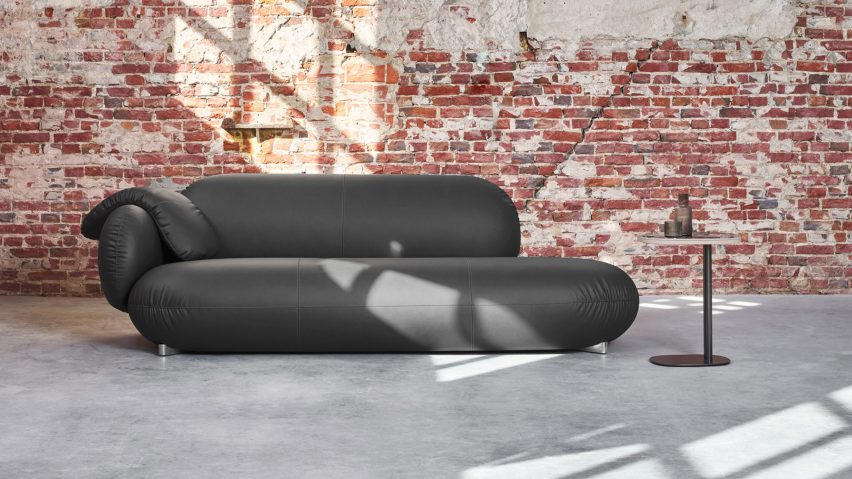 Black sofa by Leolux LX in room with distressed brick walls