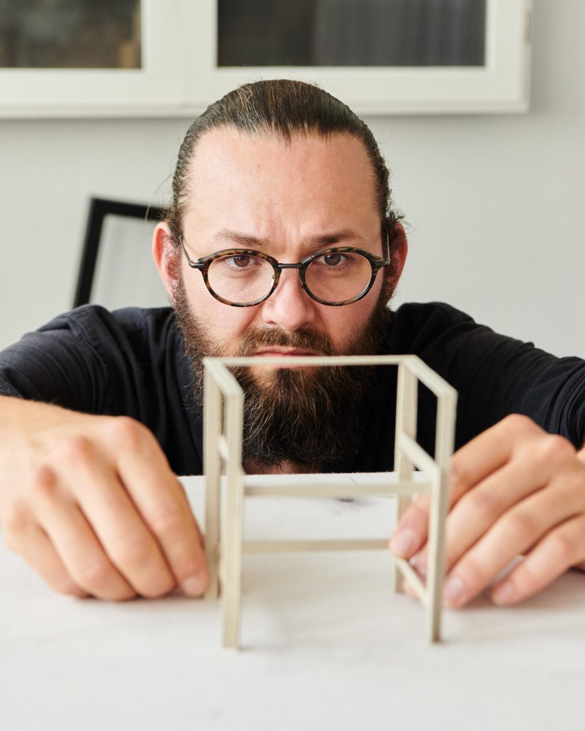 Photograph of small prototype chair in hands of designer