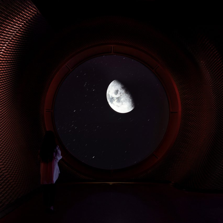 A photograph of a child looking at a digital display of the moon