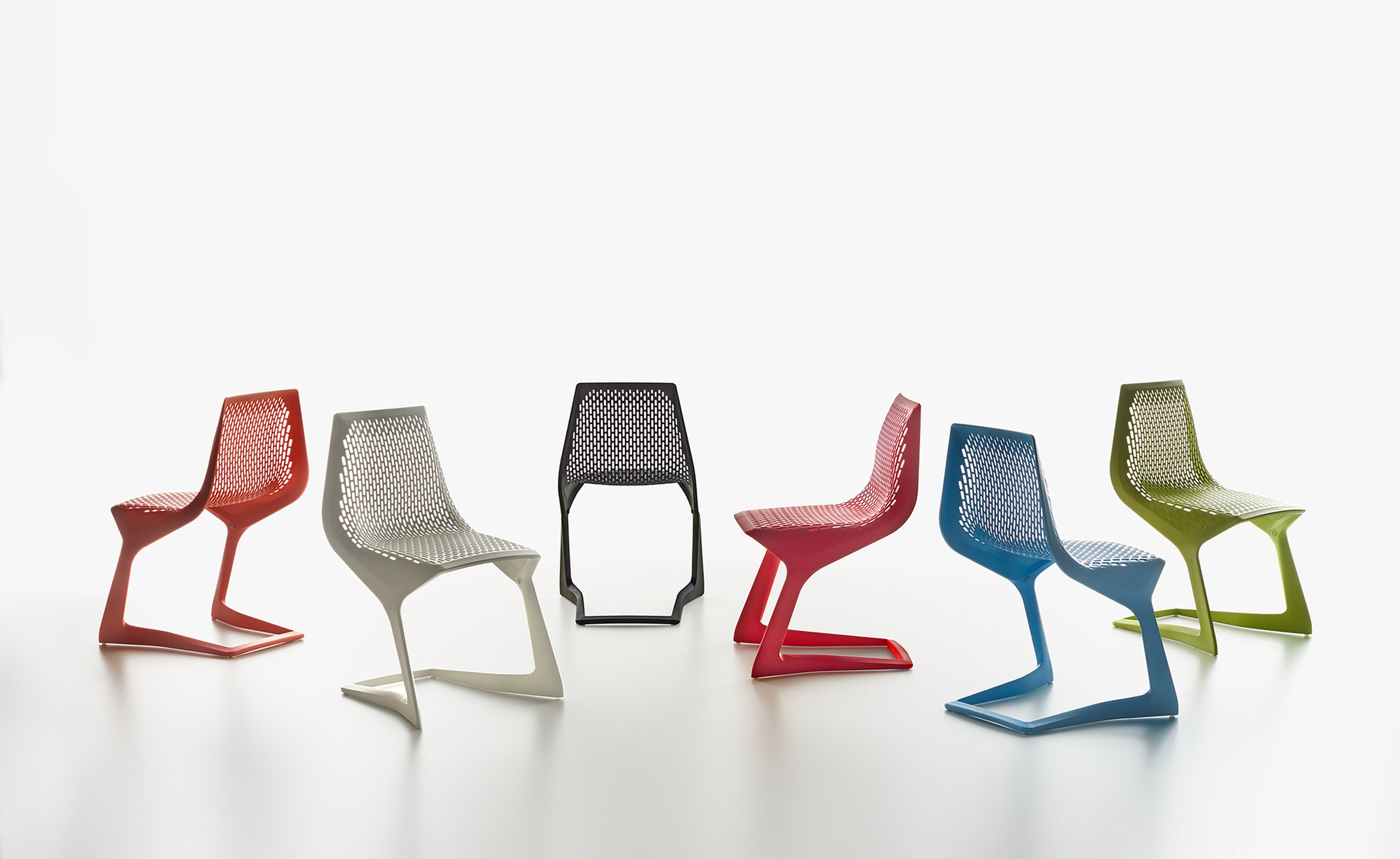 Six brightly coloured cantilevered chairs on white background