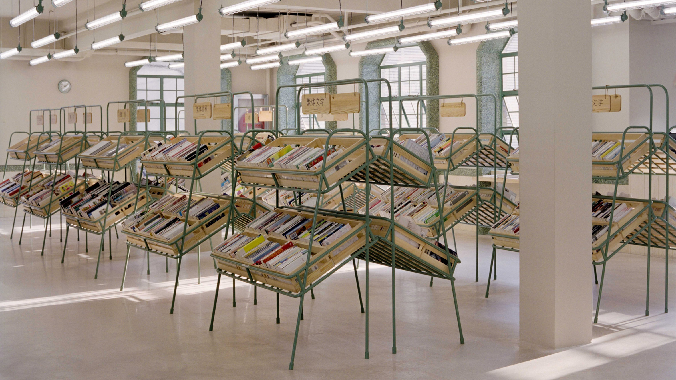 Supermarket-style shelves holding books in Deja Vu Recycle Store in Shanghai by Offhand Practice