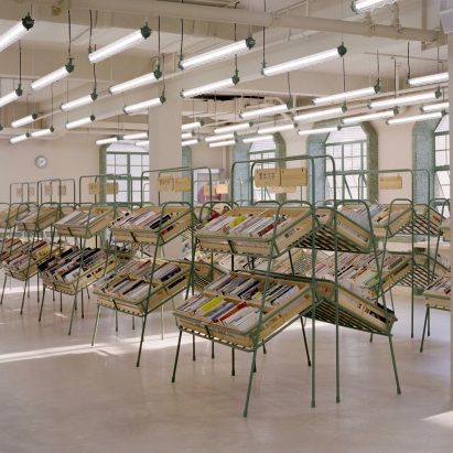 Supermarket-style shelves holding books in Deja Vu Recycle Store in Shanghai by Offhand Practice