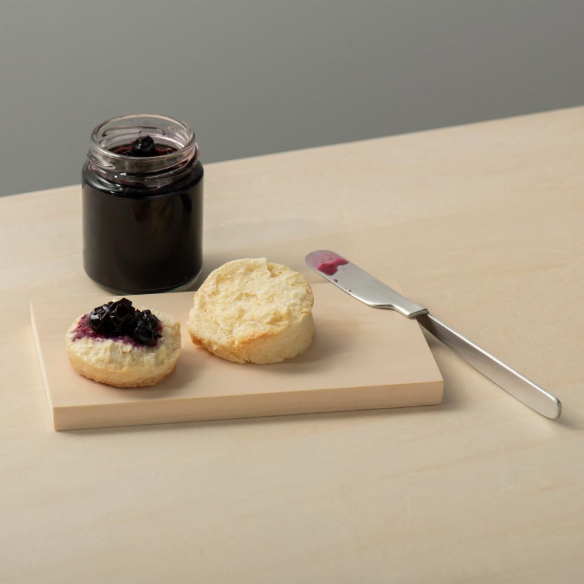 Oku knife by Kathleen Reilly on the edge of a wood chopping board with jam and scones