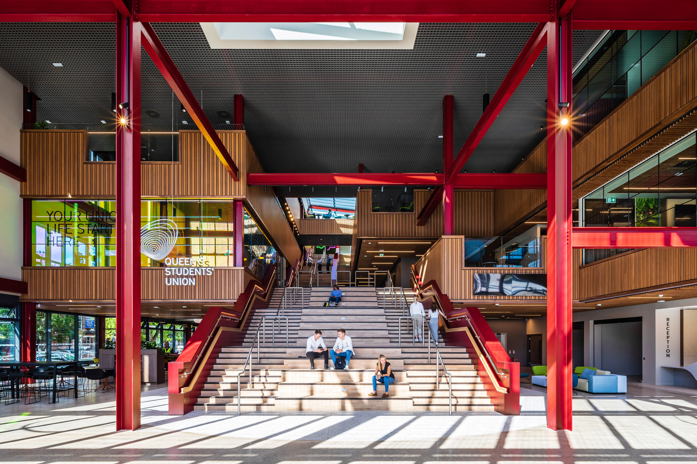 Atrium with bleacher seating and red steelwork