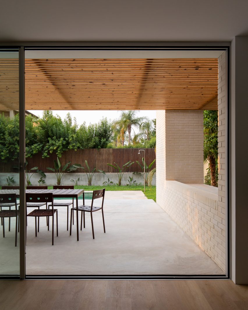 Glass sliding doors open up to a covered outdoor dining area at Brick House