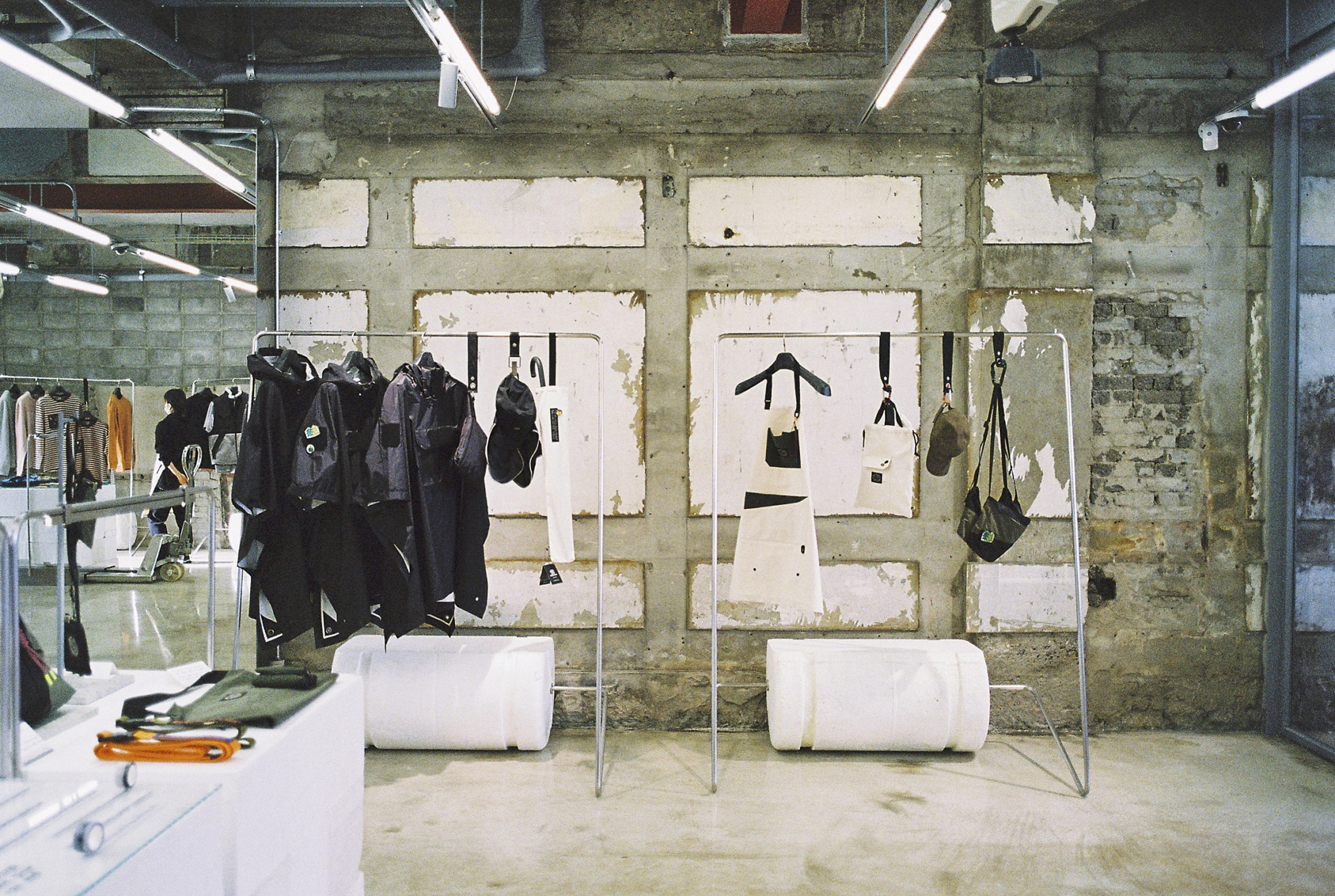 Interior image of the Kolon Sport store with clothing displayed beside concrete walls