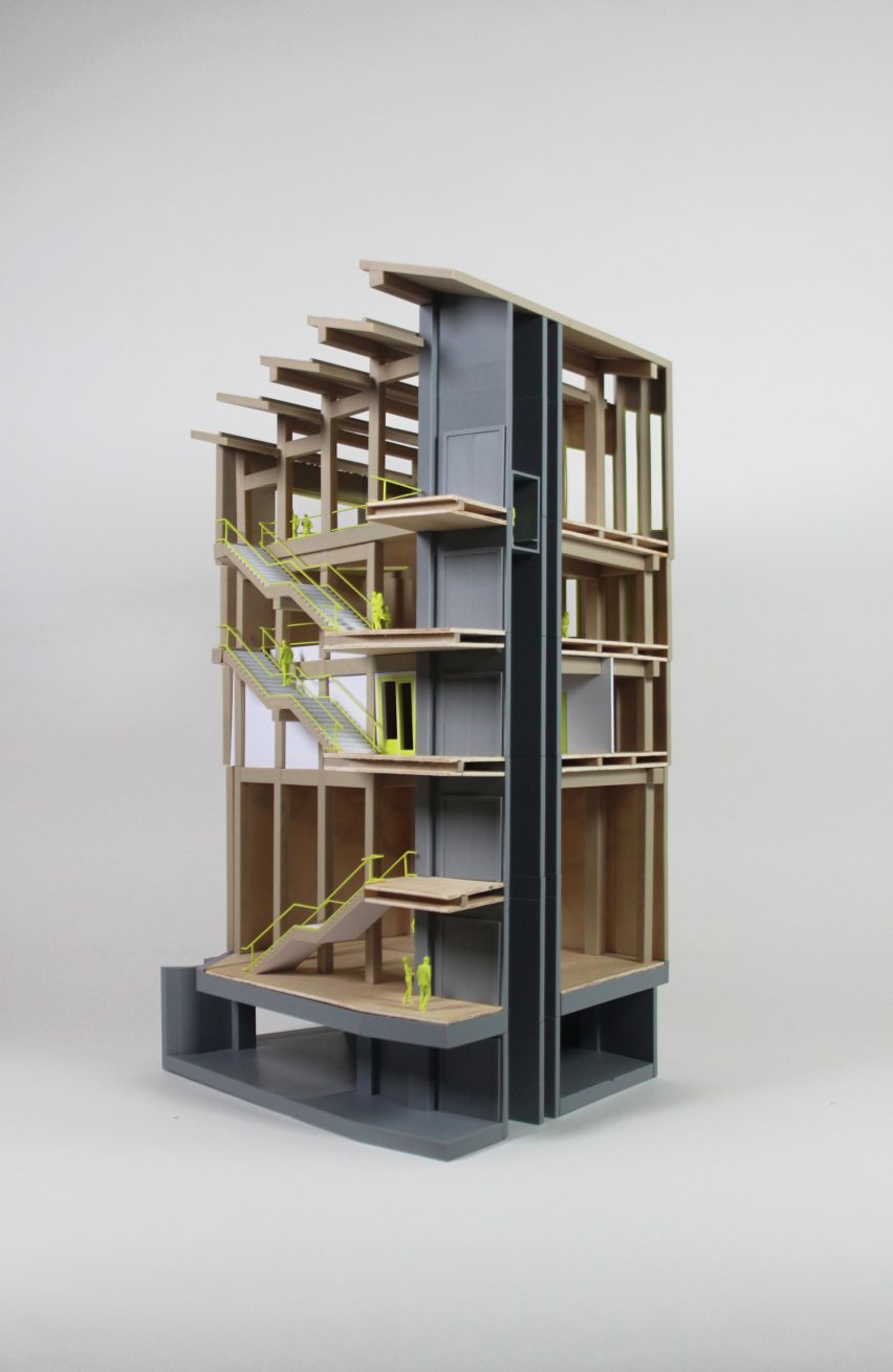 A photograph of an architectural model in tones of brown, grey and green against a white backdrop.