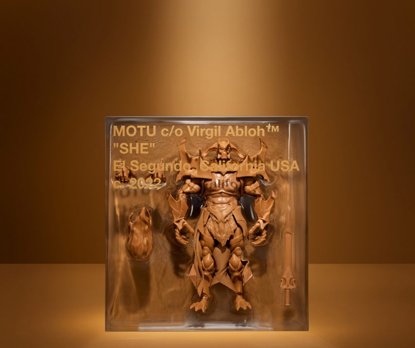 clear plastic box containing a brown action figure and reading "MOTU c/o Virgil Abloh, 'SHE', El Segundo, California USA, c. 2022