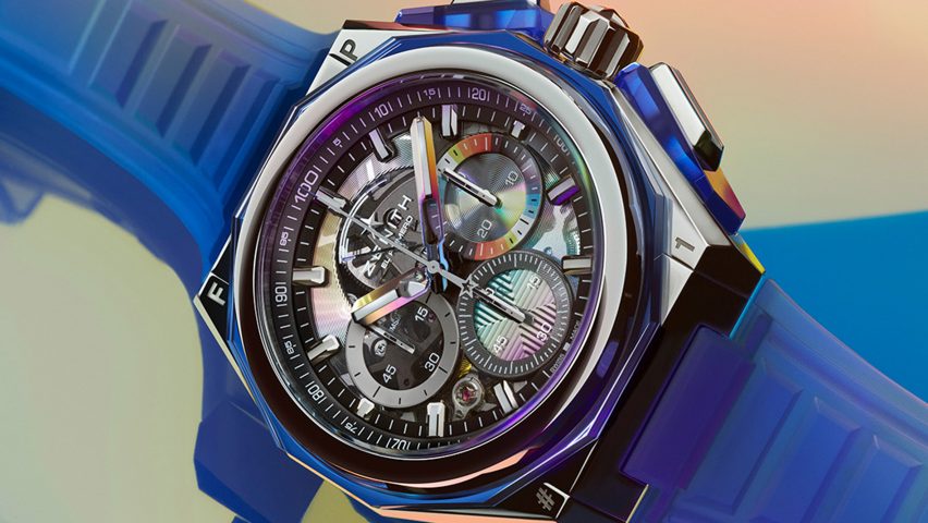 A close-up photograph of Zenith watch with a rainbow background
