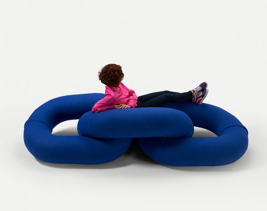 A person sitting on a blue link sofa