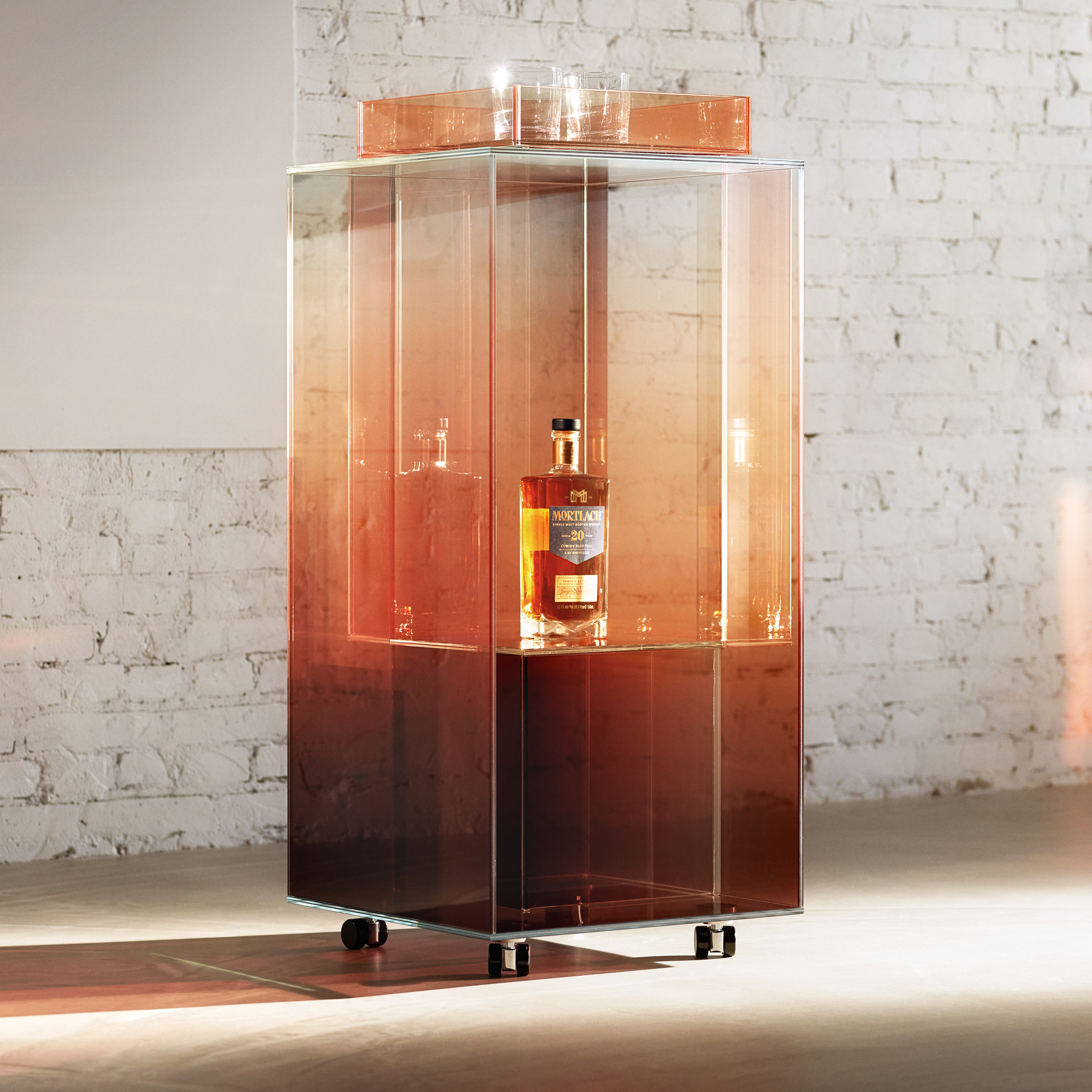 A whisky-coloured bar cart made from panels of glass