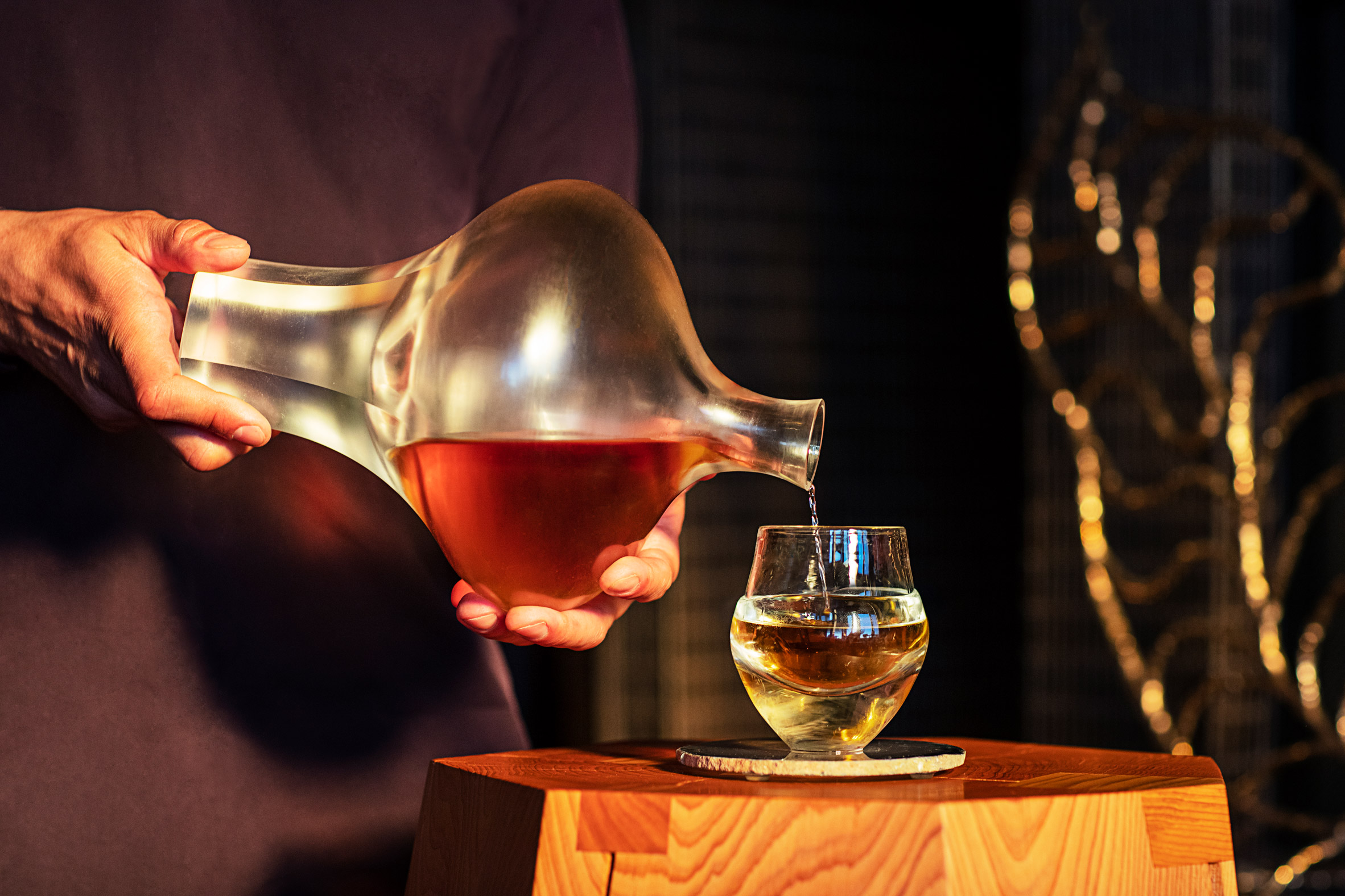 A photograph of whisky being poured from a decanter