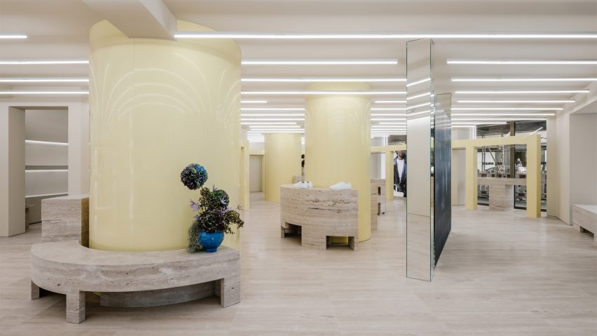 Glossy butter yellow columns and travertine plinths in Axel Arigato's Berlin store