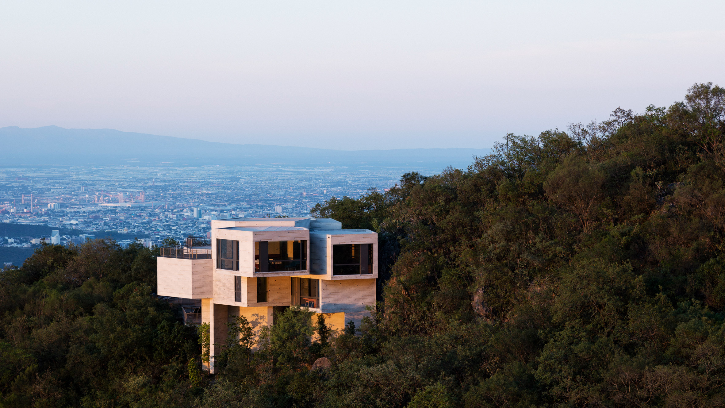 Casa Ventura emerging from the forested hillside