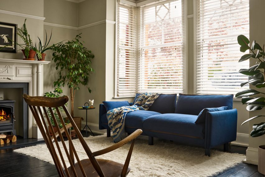 Sofa with blue cover in living room with bay window