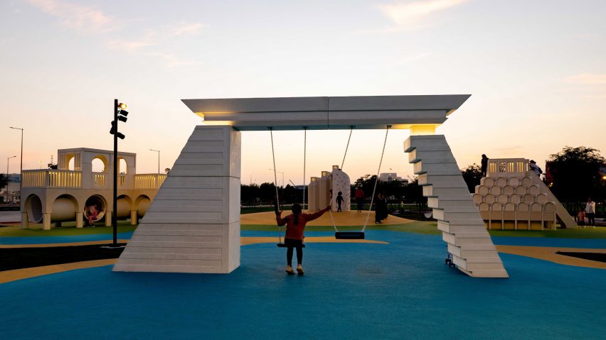 Child on a swing set that looks like a building in Doha