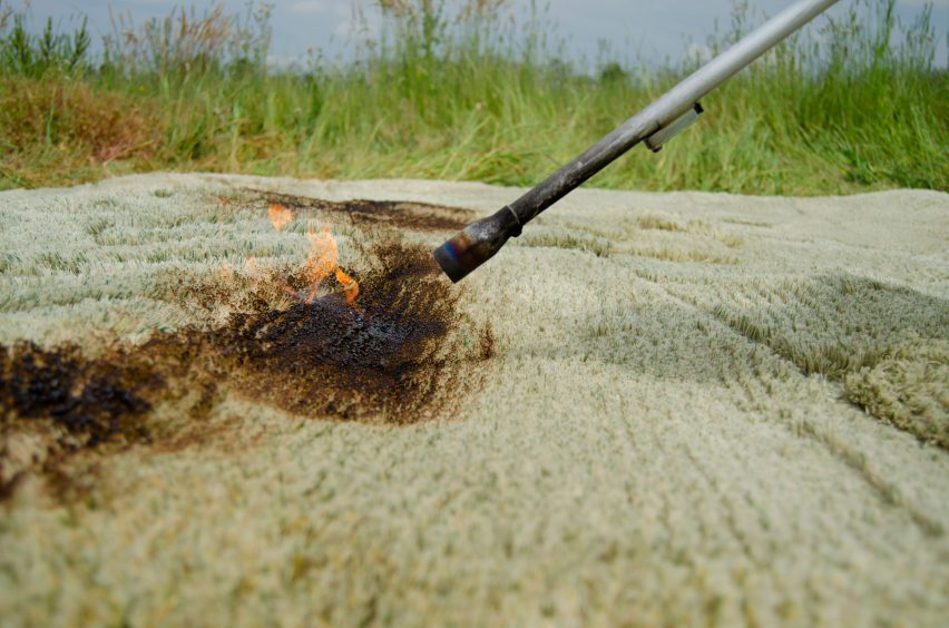 Close-up of flame thrower burning the fibres of a grassy rug by Liselot Cobelens outdoors in a meadow