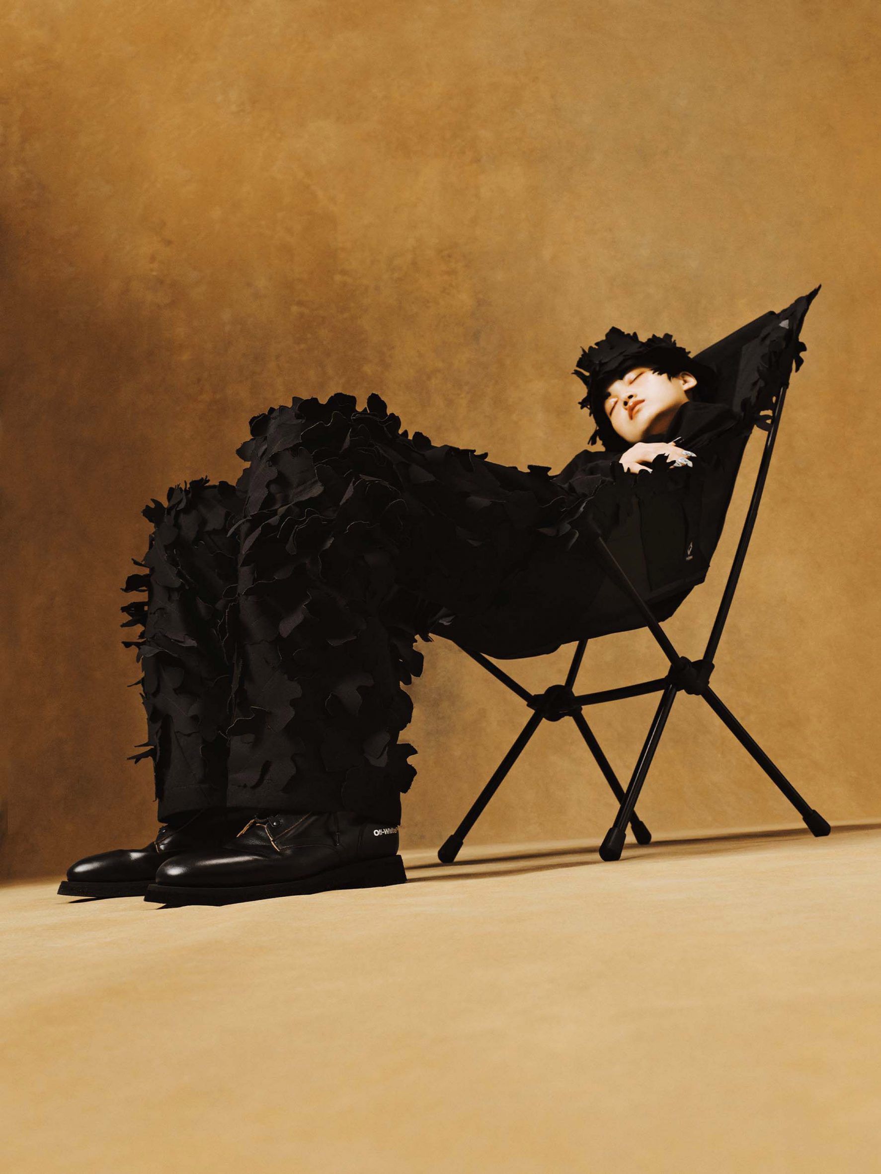 Model sat in chair wearing black out fit with applique leafs