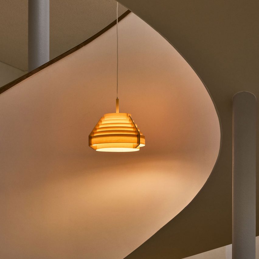 Orange glowing lamp suspended in the middle of a spiral staircase