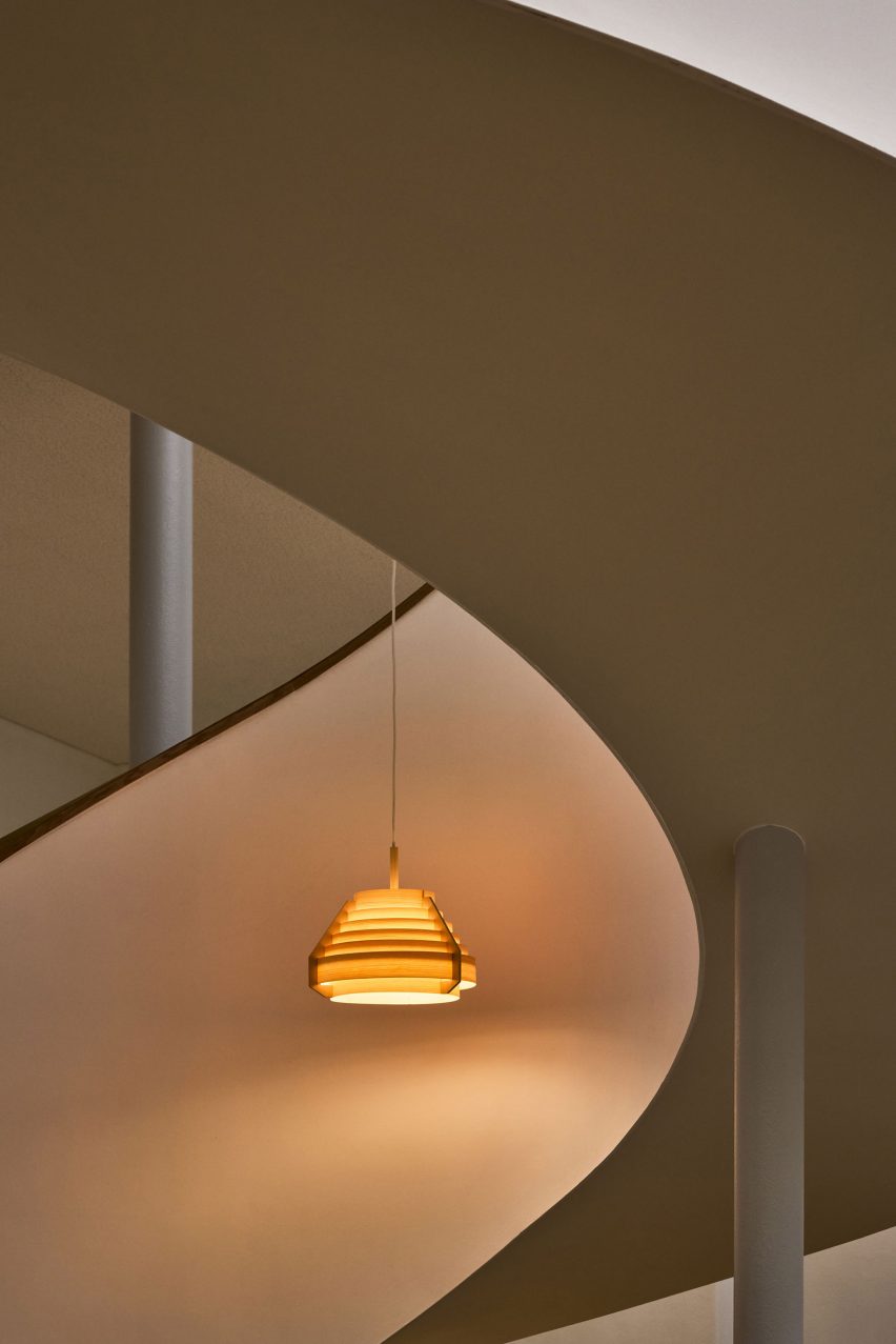 Orange glowing lamp suspended in the middle of a spiral staircase