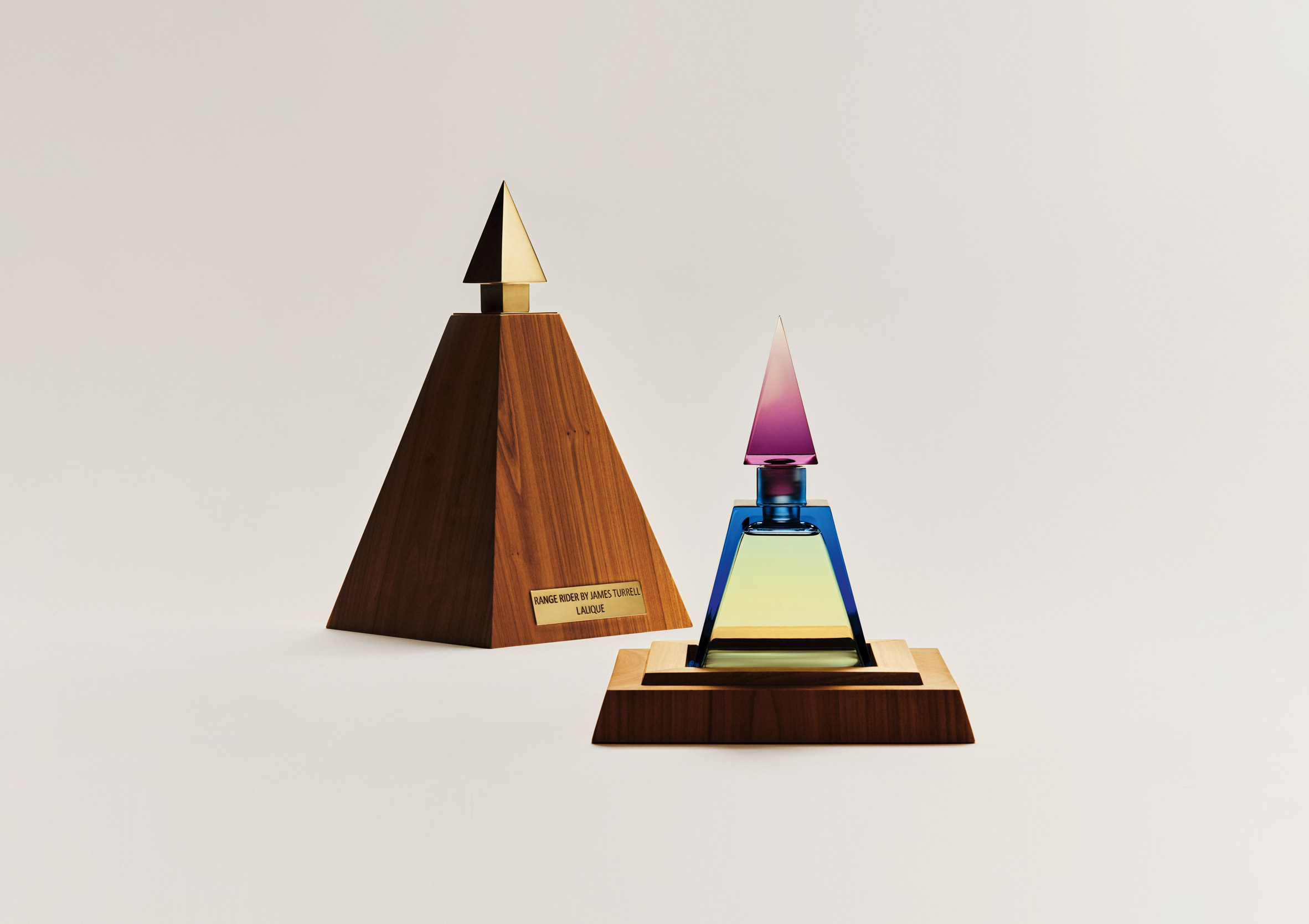 A pyramid shaped perfume bottle and a wooden case