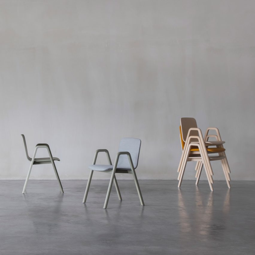 Two chairs and stack of chairs on gray background