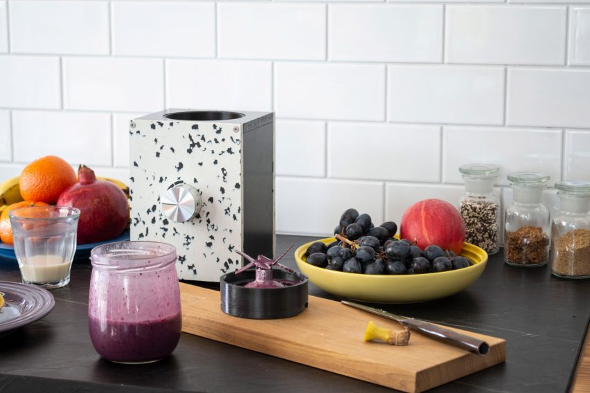 Base of a blender on a kitchen bench surrounded by fruit