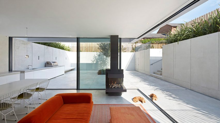 Interior image of a home with glass sliding doors that open up to a concrete garden