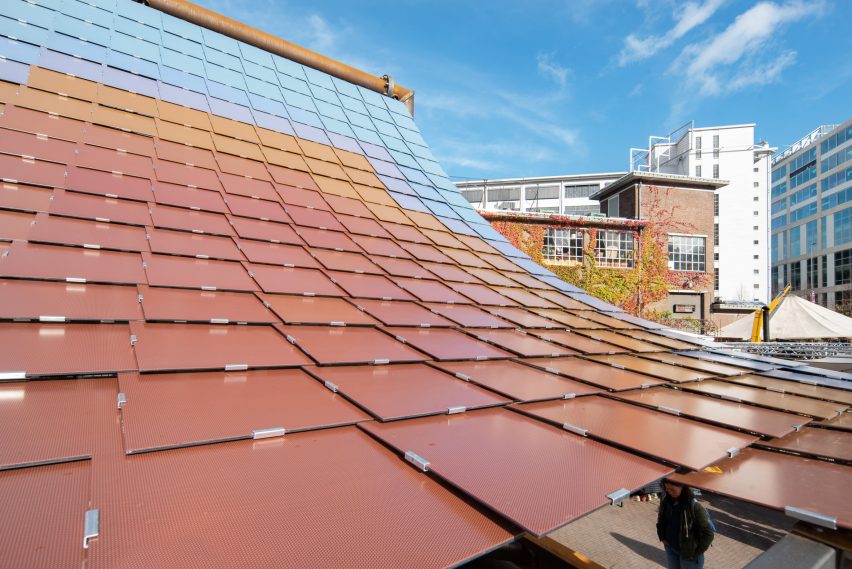 Red, orange and blue solar panels on a curved roof