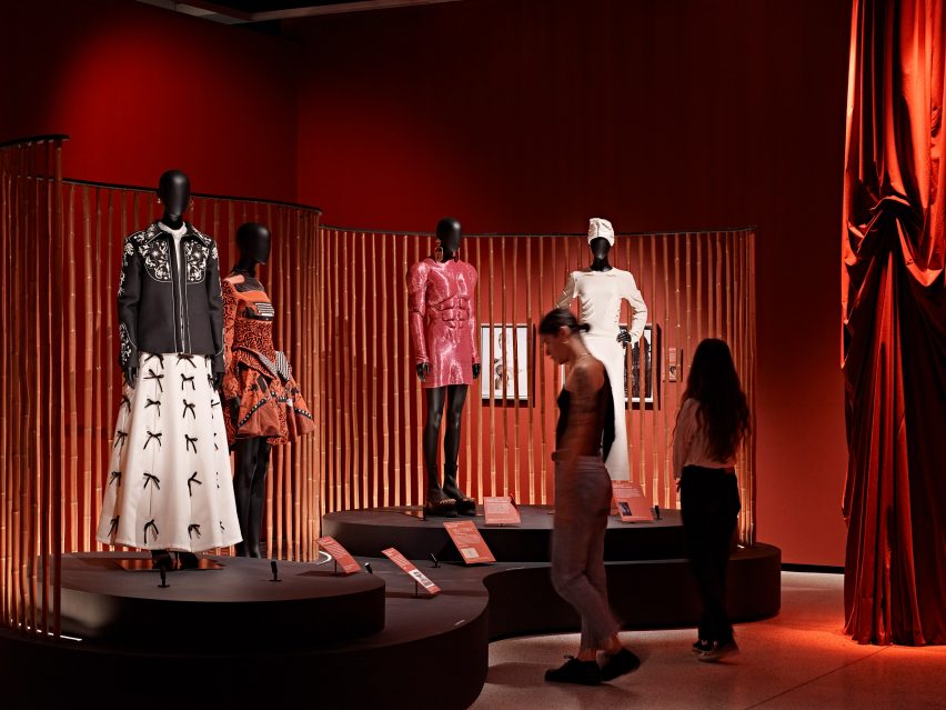 Visitors looking at four mannequins wearing fashion inspired by surrealism